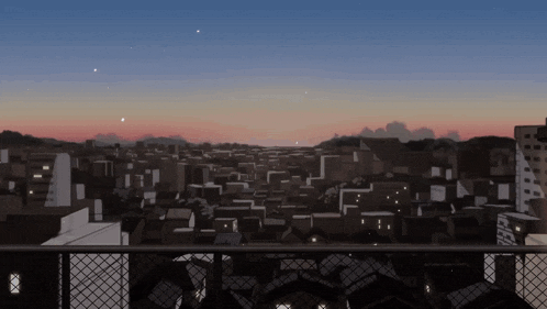 a view of a city from a balcony with a sunset in the background