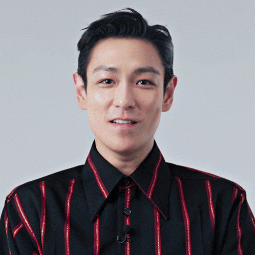 a man in a black and red striped shirt smiles for the camera