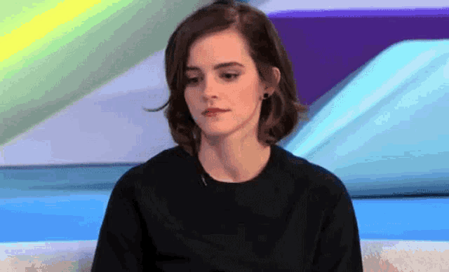 a woman is sitting on a couch and looking at the camera .