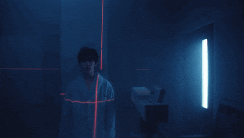 a person standing in a dark room with a red line coming out of it