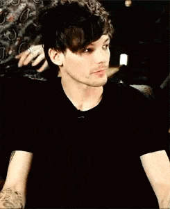 a close up of a man wearing a black shirt and looking at the camera .