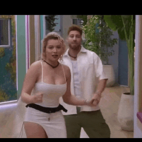 a man and a woman are dancing in a hallway holding hands