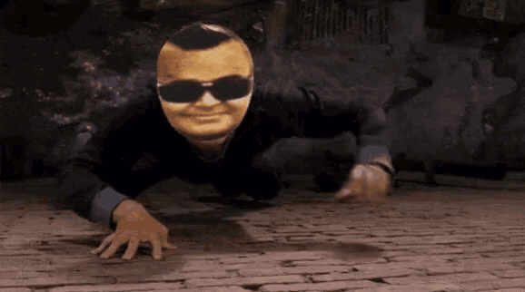 a man wearing sunglasses and a mask is crawling on a brick floor