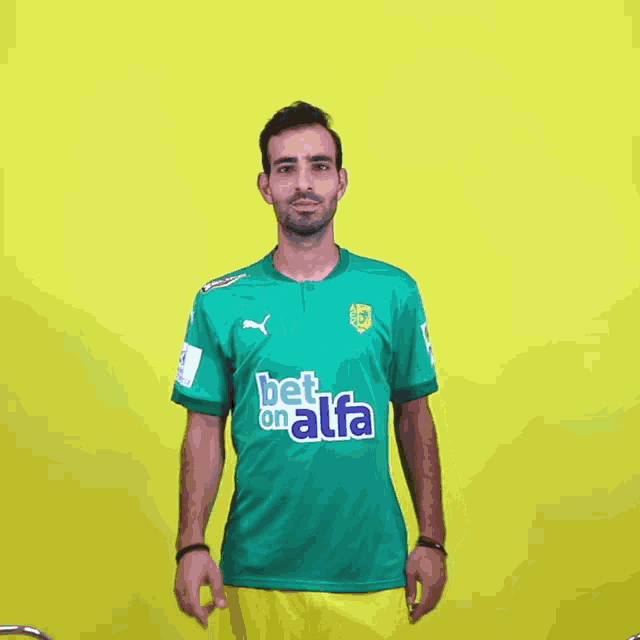 a man wearing a green shirt that says bet on alfa on it