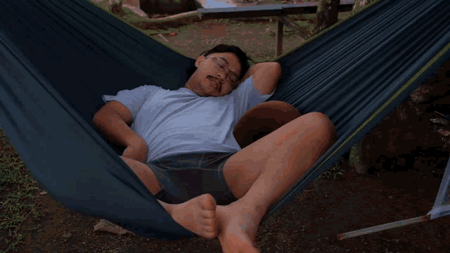 a man laying in a hammock with a pillow that says klm