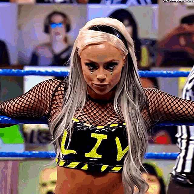 a woman in a wrestling ring wearing a top that says liv on it