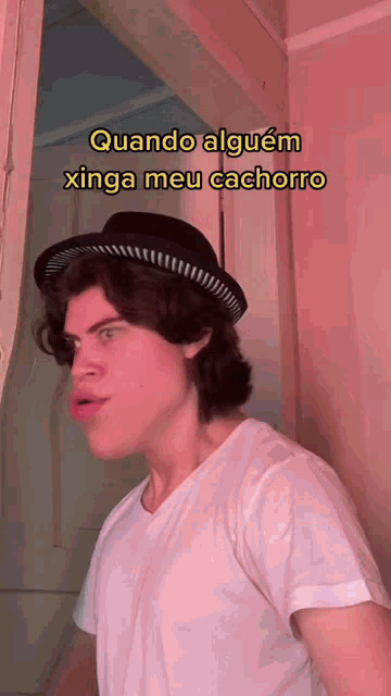 a man wearing a hat and a white shirt says " quando alguem xinga meu cachorro "
