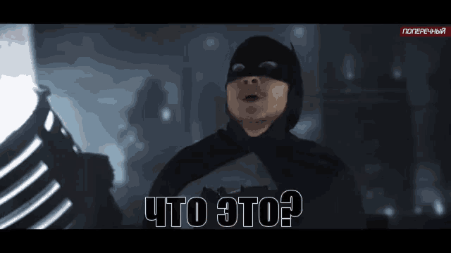 a man in a batman costume is standing in the dark and asking what is this ?
