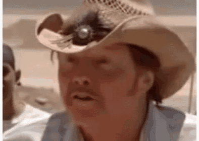 a man wearing a cowboy hat and a blue shirt is making a face .