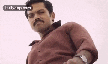 a man with a mustache wearing a red shirt and a watch .
