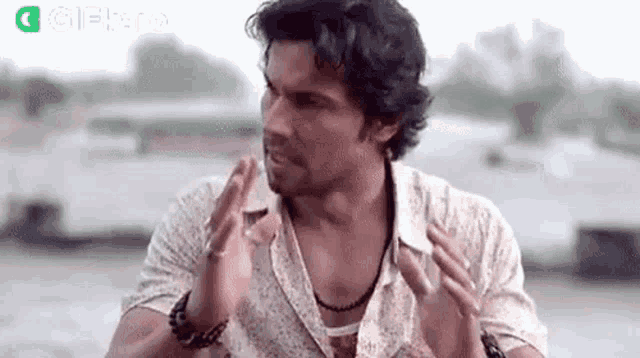 a man is making a funny face with his hands .