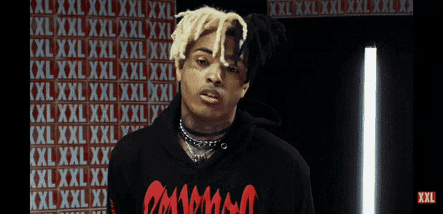 a man wearing a black hoodie that says xxl on it
