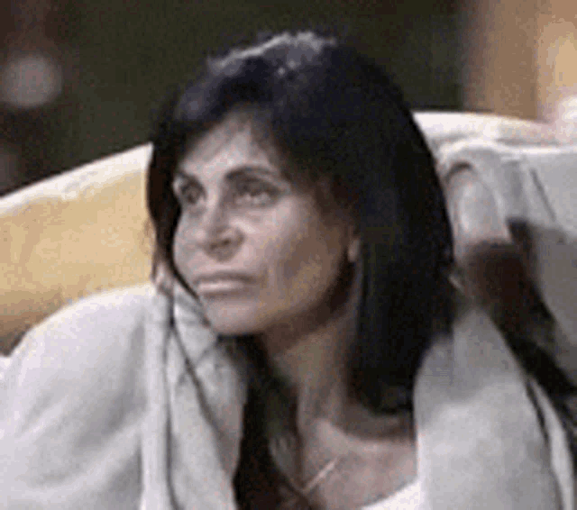 a woman with long black hair is sitting in a chair with her head on a pillow .