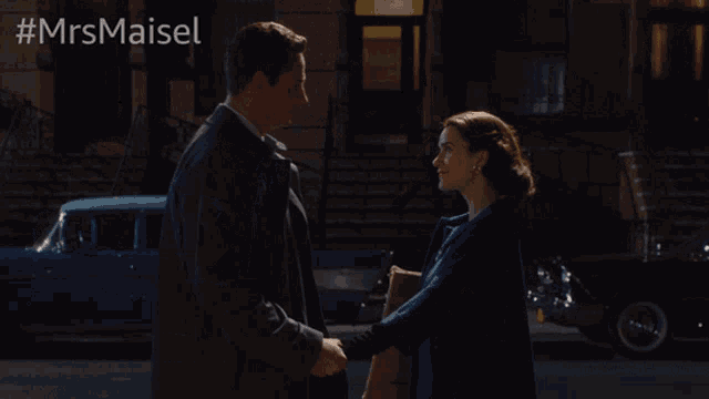 a man and woman are shaking hands in front of a building with #mrsmaiset written above them