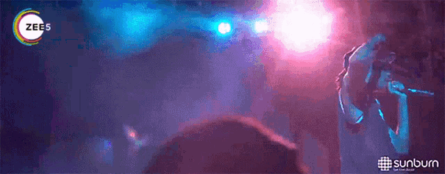 a woman singing into a microphone with the word zee 's on the bottom