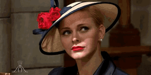 a woman wearing a hat with a red flower on it