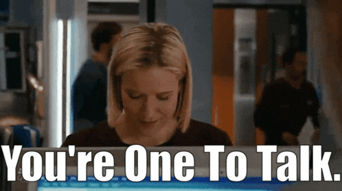 a woman sitting in front of a computer with the words " you 're one to talk " written below her