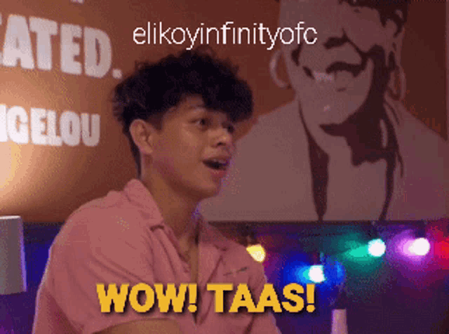a man in a pink shirt says wow taas in front of a poster