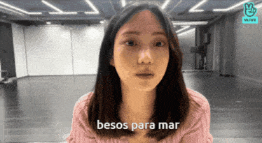 a woman in a pink sweater says " besos para mar " in spanish