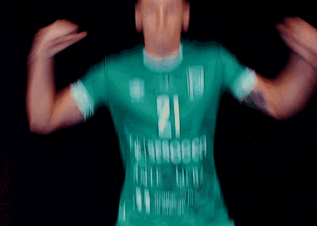 a blurry picture of a man wearing a green shirt that says 21