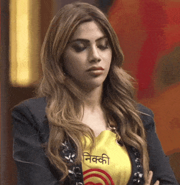 a woman wearing a yellow shirt that says nikki