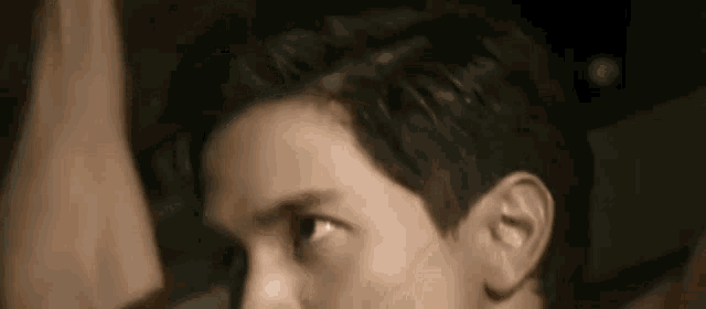 a close up of a man 's face with his eyes closed and his hair visible .