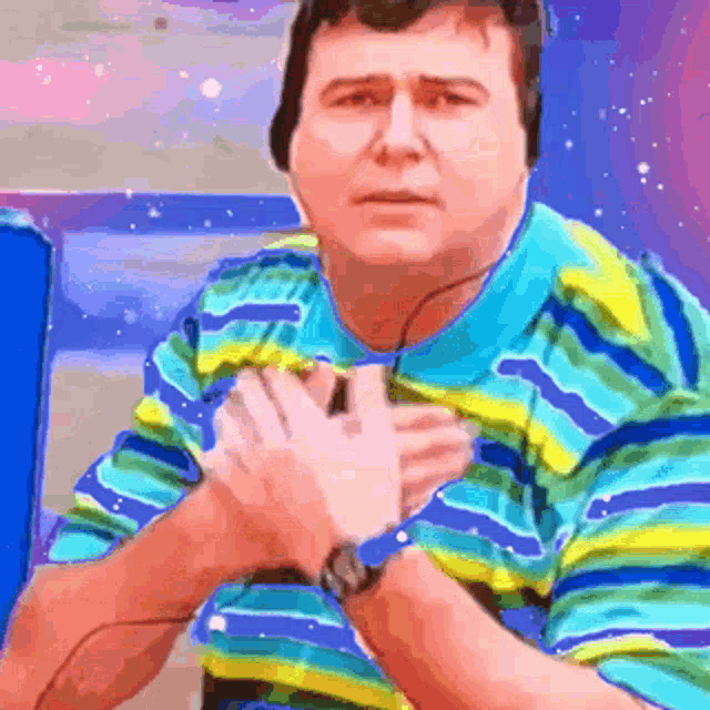 a man wearing headphones and a striped shirt is holding his chest