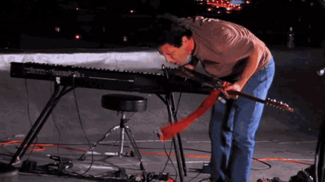 a man in a brown shirt is playing a keyboard