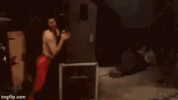 a man in red pants is standing in front of a box on a stage .