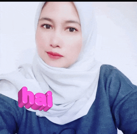a woman wearing a white hijab and a blue shirt with the word hai written in pink
