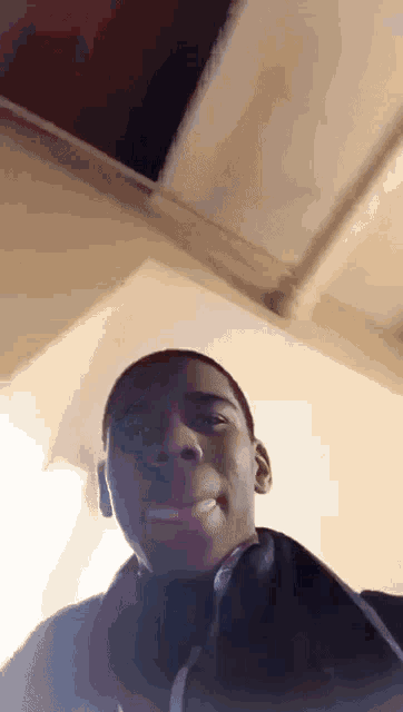 a man wearing headphones is smiling and looking up at the camera