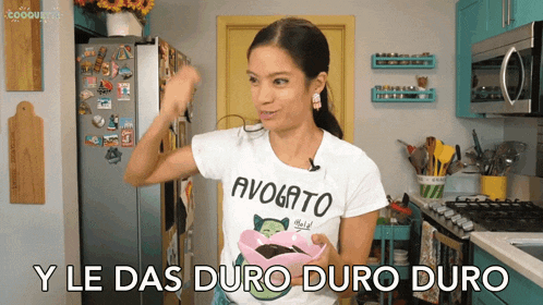 a woman wearing a t-shirt that says avogato holds a bowl