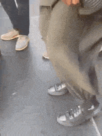 a close up of a person 's feet wearing sneakers on a black floor .