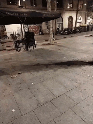 a black umbrella that says cerveceria is on the sidewalk