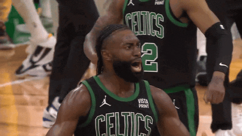 a basketball player wearing a celtics jersey stands on the court
