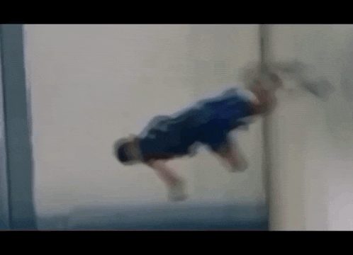 a person is doing a handstand on a wall in a room .