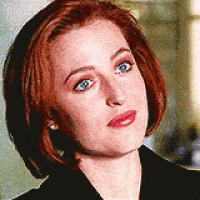 a woman with red hair and blue eyes is looking at the camera .