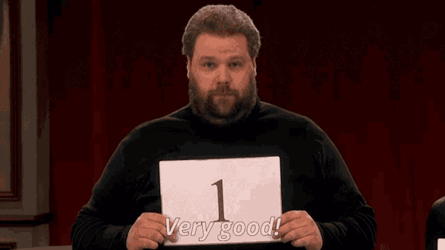 a man with a beard is holding a piece of paper that says very good