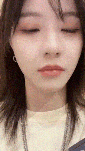 a woman with her eyes closed wearing a white shirt