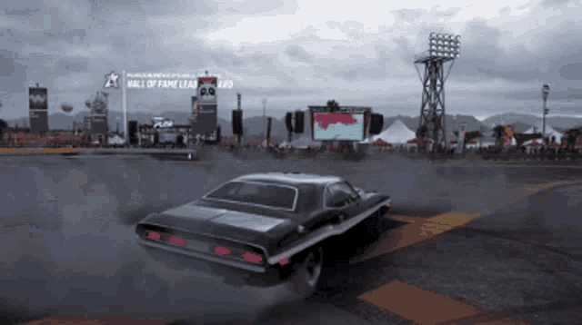 a car is driving past a sign that says hall of fame