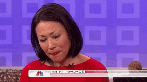 a woman is crying on a television show while wearing a red dress .