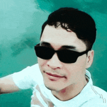 the man is wearing sunglasses and a white shirt .