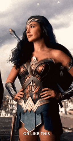 a woman in a wonder woman costume is holding a sword with her hands on her hips .