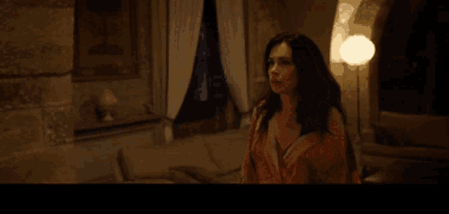 a woman standing in a dark room with the words fuck me on the screen
