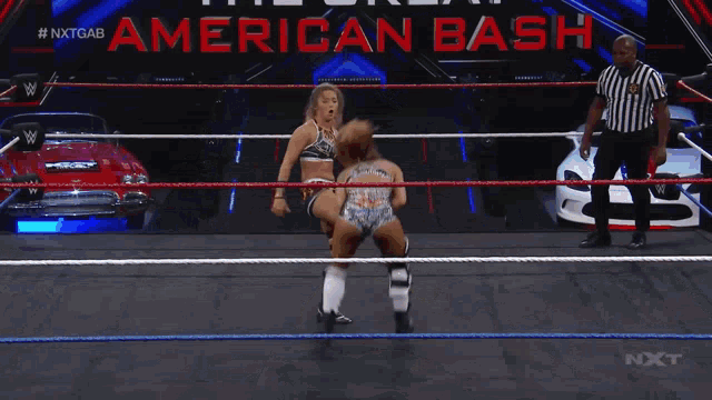 two women are wrestling in a ring with a referee in front of a sign that says " american bash "
