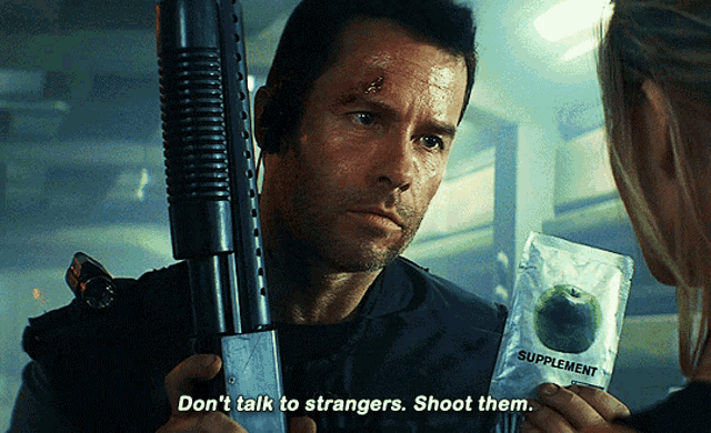 a man holding a gun and a packet of supplements says " don 't talk to strangers shoot them "