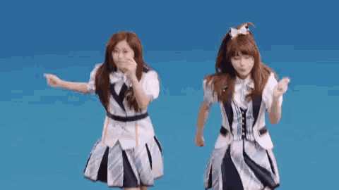 two girls are dancing together on a blue background .