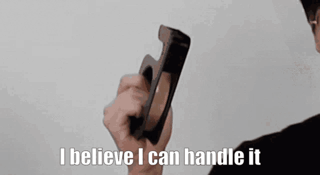 a man wearing glasses is holding a tape dispenser and says i believe i can handle it