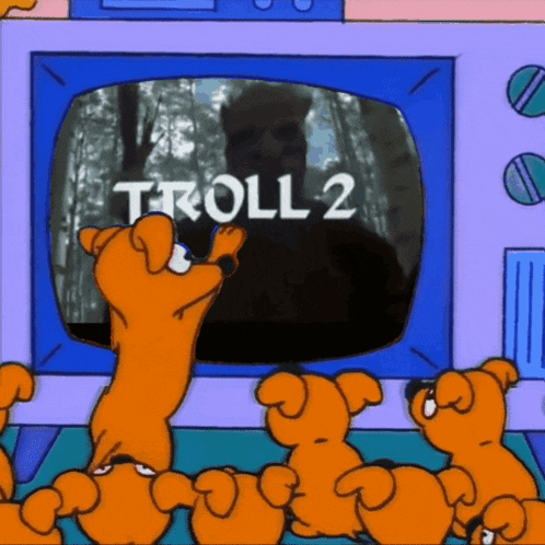 a group of cartoon dogs are looking at a television screen that says troll 2