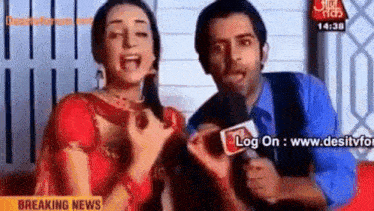 a man is holding a microphone next to a woman who is screaming in front of a breaking news sign